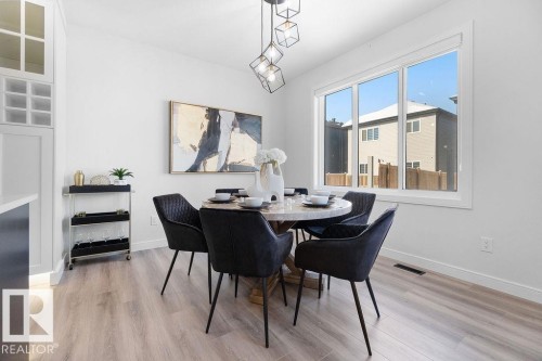 Dining room featuring light wood-type flooring and baseboards - 3722 41 Avenue, Beaumont, AB - Indoor Photo Showing Dining Room