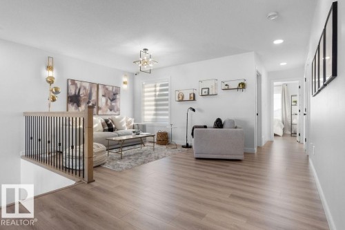 Living area with wood finished floors and suspended lighting - 3722 41 Avenue, Beaumont, AB - Indoor Photo Showing Living Room