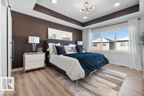 Bedroom featuring a tray ceiling, light wood-style floors, and recessed lighting - 3722 41 Avenue, Beaumont, AB - Indoor Photo Showing Bedroom