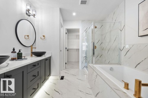 Bathroom with double vanity, a marble finish shower, a walk in closet, a garden tub, and light marble finish floors - 3722 41 Avenue, Beaumont, AB - Indoor Photo Showing Bathroom