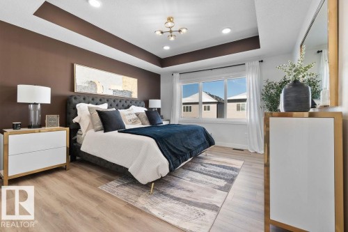 Bedroom featuring light wood-type flooring, a tray ceiling, and recessed lighting - 3722 41 Avenue, Beaumont, AB - Indoor Photo Showing Bedroom