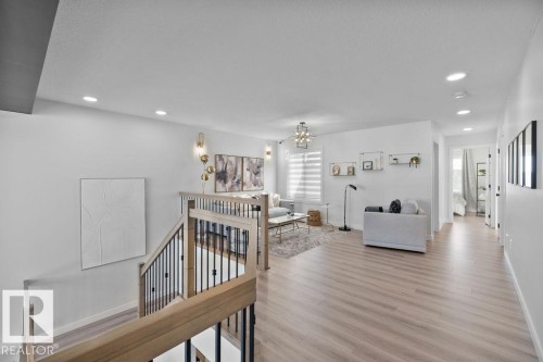 Hallway featuring an upstairs landing, suspended lighting, and light wood-type flooring - 3722 41 Avenue, Beaumont, AB - Indoor Photo Showing Other Room