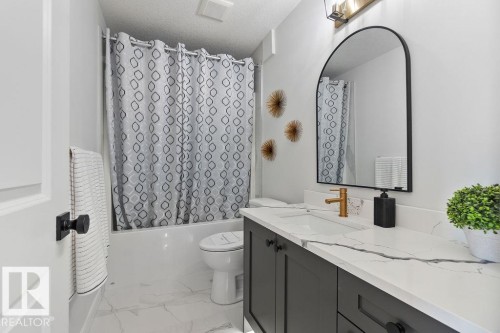 Bathroom featuring vanity, shower / tub combo, light marble finish floors, and a textured ceiling - 3722 41 Avenue, Beaumont, AB - Indoor Photo Showing Bathroom