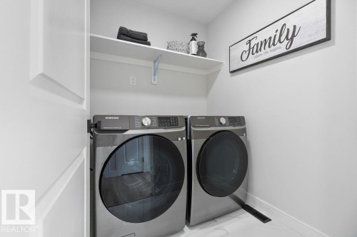Laundry area with separate washer and dryer and light marble finish floors - 3722 41 Avenue, Beaumont, AB - Indoor Photo Showing Laundry Room