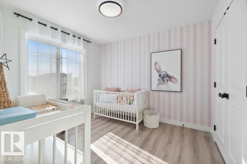 Bedroom featuring light wood finished floors and wallpapered walls - 3722 41 Avenue, Beaumont, AB - Indoor