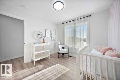 Bedroom with light wood-type flooring and a crib - 3722 41 Avenue, Beaumont, AB - Indoor