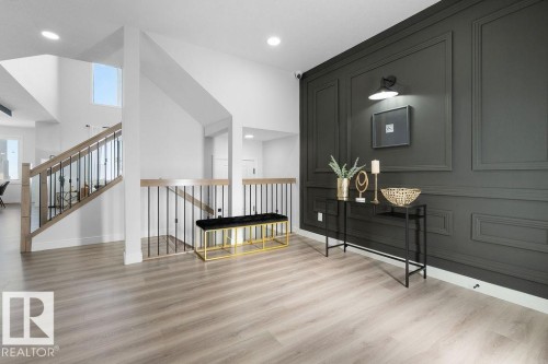 Hall featuring a decorative wall, light wood-style floors, a high ceiling, an upstairs landing, and recessed lighting - 3722 41 Avenue, Beaumont, AB - Indoor Photo Showing Other Room