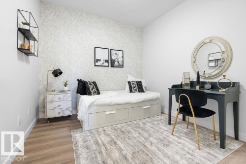 Bedroom with light wood finished floors, an accent wall, and wallpapered walls - 3722 41 Avenue, Beaumont, AB - Indoor Photo Showing Bedroom
