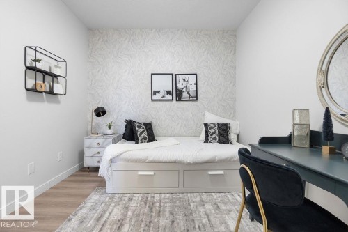 Bedroom with an accent wall, light wood-style flooring, a desk, and wallpapered walls - 3722 41 Avenue, Beaumont, AB - Indoor