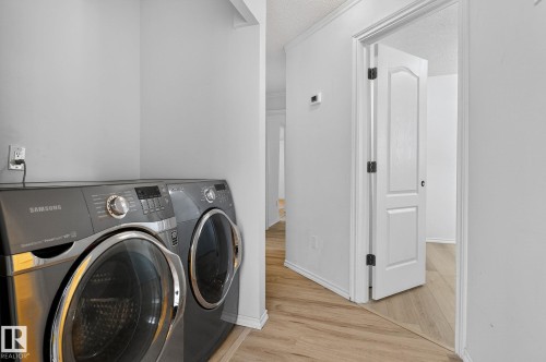 Laundry area featuring separate washer and dryer, light wood-type flooring, and a textured ceiling - 72 Evergreen Park, Edmonton, AB - Indoor Photo Showing Laundry Room