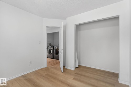 Laundry area featuring washing machine and dryer, light wood-style flooring, and a textured ceiling - 72 Evergreen Park, Edmonton, AB - Indoor Photo Showing Other Room