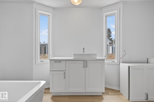 Full bath featuring vanity, a freestanding tub, light wood-type flooring, plenty of natural light, and a textured ceiling - 72 Evergreen Park, Edmonton, AB - Indoor Photo Showing Other Room