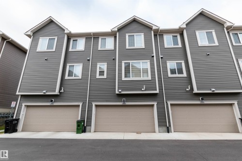 Back of property featuring an attached garage and driveway - 105 2072 Wonnacott Way, Edmonton, AB - Outdoor