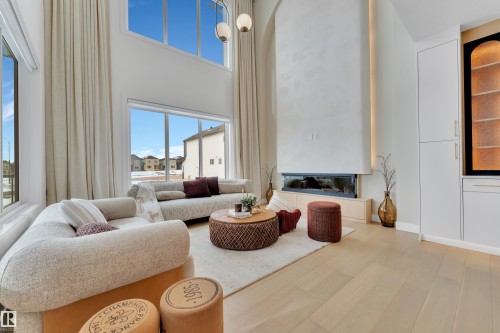 Living room with light wood finished floors, a high ceiling, and plenty of natural light - 2408 1 Ave Sw, Edmonton, AB - Indoor Photo Showing Living Room