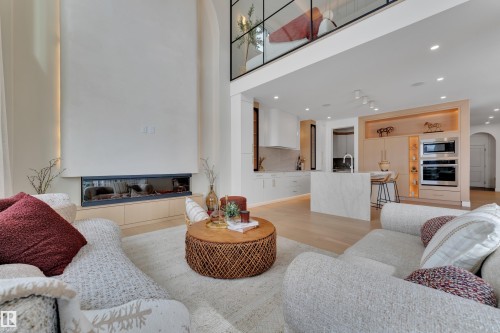 Living room with arched walkways, light wood-style floors, recessed lighting, and a high ceiling - 2408 1 Ave Sw, Edmonton, AB - Indoor Photo Showing Living Room