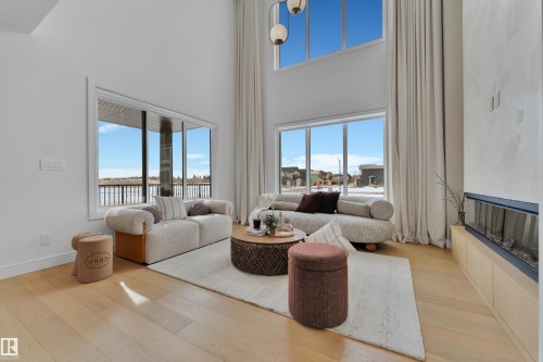 Living area featuring light wood-style flooring, a high ceiling, and healthy amount of natural light - 2408 1 Ave Sw, Edmonton, AB - Indoor Photo Showing Living Room