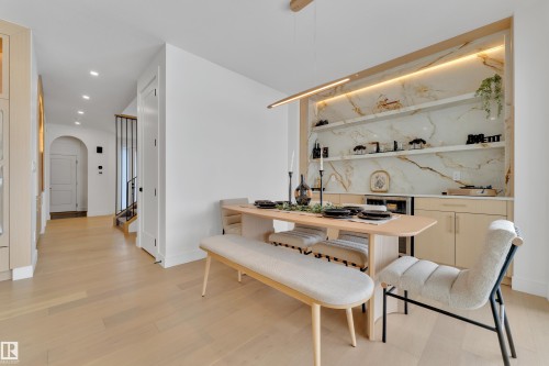 Dining space with arched walkways, wine cooler, recessed lighting, and light wood-style floors - 2408 1 Ave Sw, Edmonton, AB - Indoor Photo Showing Dining Room