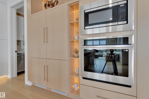 Kitchen with stainless steel appliances, open shelves, light wood-style flooring, and light wood finish cabinets - 2408 1 Ave Sw, Edmonton, AB - Indoor Photo Showing Kitchen