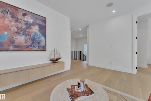 Sitting room with an upstairs landing, light wood-style flooring, and recessed lighting - 2408 1 Ave Sw, Edmonton, AB - Indoor