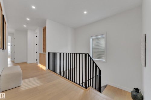 Hall featuring an upstairs landing, recessed lighting, light wood finished floors, healthy amount of natural light, and built in features - 2408 1 Ave Sw, Edmonton, AB - Indoor Photo Showing Other Room