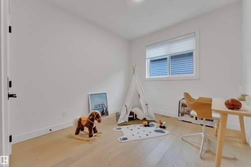 Game room with light wood finished floors and baseboards - 2408 1 Ave Sw, Edmonton, AB - Indoor