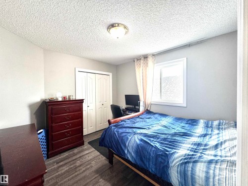 Bedroom featuring dark wood-style floors, a closet, and a textured ceiling - 6734 162A Avenue, Edmonton, AB - Indoor Photo Showing Bedroom