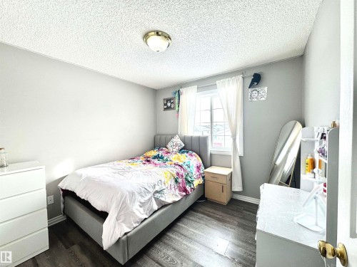 Bedroom with dark wood-style flooring and a textured ceiling - 6734 162A Avenue, Edmonton, AB - Indoor Photo Showing Bedroom
