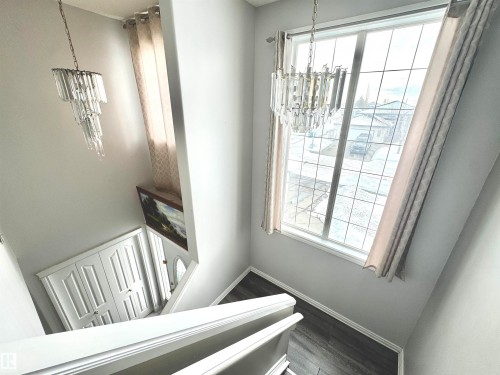 Stairs with suspended lighting and wood finished floors - 6734 162A Avenue, Edmonton, AB - Indoor Photo Showing Other Room