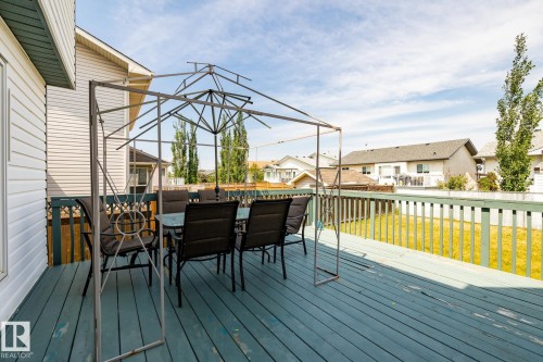 Wooden deck featuring a residential view, outdoor dining area, and a lawn - 6734 162A Avenue, Edmonton, AB - Outdoor With Deck Patio Veranda With Exterior