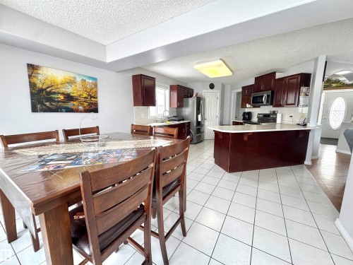Dining area featuring a textured ceiling and light tile patterned flooring - 6734 162A Avenue, Edmonton, AB - Indoor
