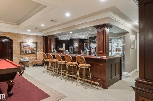 Community bar area featuring ornamental molding, billiards, dark wood finish cabinets, and dark countertops - 108 Westbrook Drive, Edmonton, AB - Indoor Photo Showing Other Room