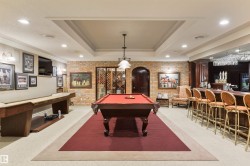 Recreation room with brick wall, billiards, ornamental molding, a raised ceiling, and recessed lighting - 