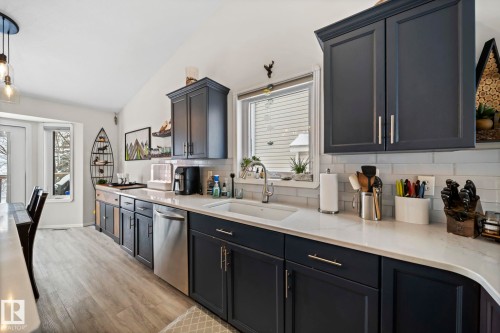 Kitchen with healthy amount of natural light, open shelves, light wood-style flooring, and tasteful backsplash - 103 Adams Close, Red Deer, AB - Indoor Photo Showing Kitchen