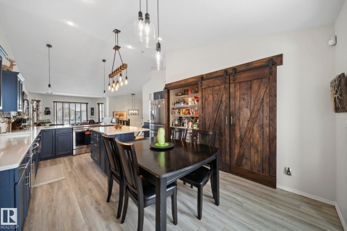 Dining area with a barn door, light wood finished floors, and vaulted ceiling - 103 Adams Close, Red Deer, AB - Indoor