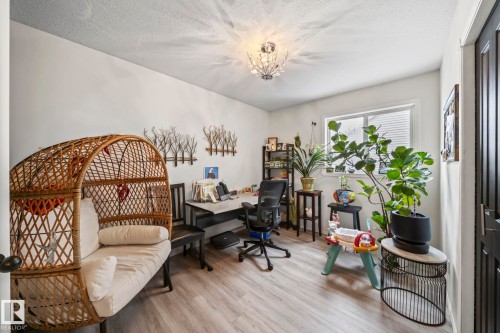 Office space with light wood-type flooring, a textured ceiling, and hanging lights - 103 Adams Close, Red Deer, AB - Indoor