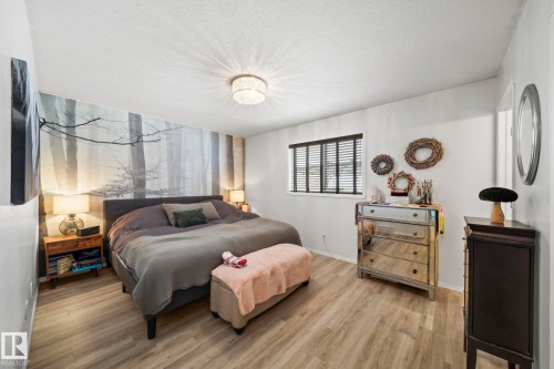 Bedroom featuring wood finished floors and a textured ceiling - 103 Adams Close, Red Deer, AB - Indoor Photo Showing Bedroom