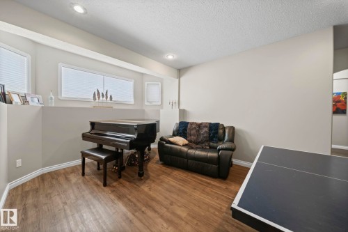 Sitting room with wood finished floors, recessed lighting, and a textured ceiling - 103 Adams Close, Red Deer, AB - Indoor