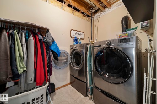 Laundry area with washer and dryer and light tile patterned flooring - 103 Adams Close, Red Deer, AB - Indoor Photo Showing Laundry Room