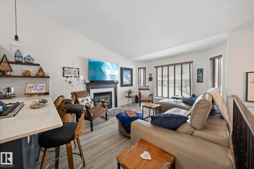 Living room with a tiled fireplace and vaulted ceiling - 103 Adams Close, Red Deer, AB - Indoor Photo Showing Living Room With Fireplace