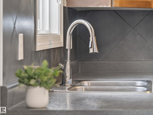 Kitchen view of a sink and white cabinets - 125 655 Tamarack Road, Edmonton, AB - Indoor Photo Showing Kitchen With Double Sink