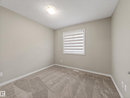 Unfurnished room featuring carpet and a textured ceiling - 125 655 Tamarack Road, Edmonton, AB - Indoor Photo Showing Other Room