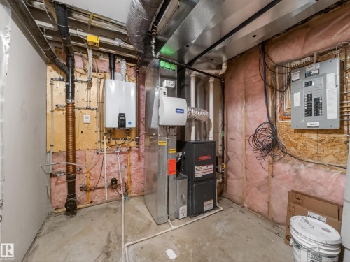 Utility room with heating unit, electric panel, and tankless water heater - 125 655 Tamarack Road, Edmonton, AB - Indoor Photo Showing Basement