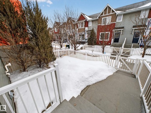 Snowy yard featuring a residential view, a fenced backyard, and a wooden deck - 125 655 Tamarack Road, Edmonton, AB - Outdoor