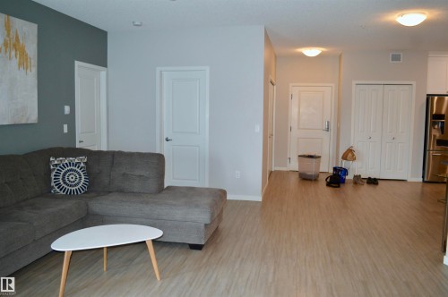 Living room with light wood-type flooring and baseboards - 437 1818 Rutherford Road, Edmonton, AB - Indoor Photo Showing Living Room