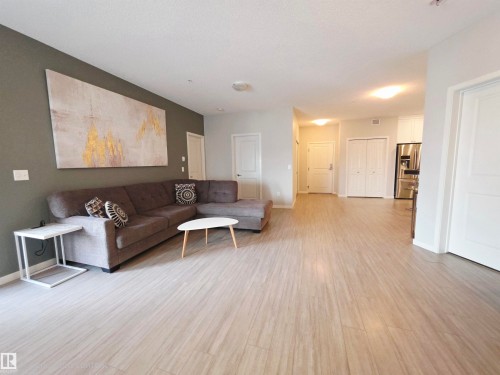 Living room with baseboards and light wood-style floors - 437 1818 Rutherford Road, Edmonton, AB - Indoor Photo Showing Other Room