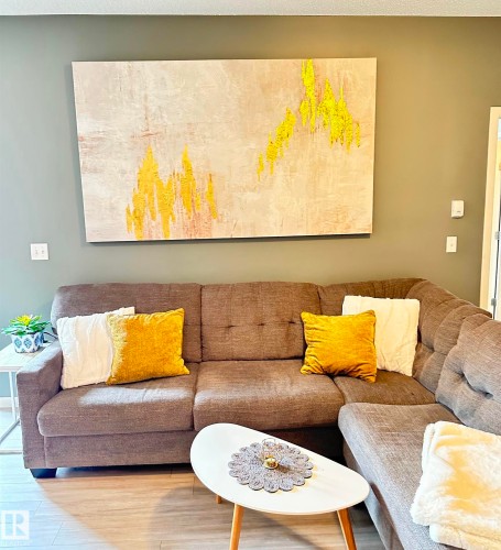Light wood-finish flooring complements the neutral wall color - 437 1818 Rutherford Road, Edmonton, AB - Indoor Photo Showing Living Room