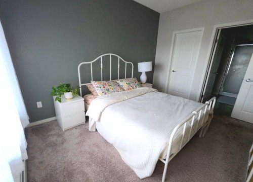 Bedroom with carpet flooring and baseboards - 437 1818 Rutherford Road, Edmonton, AB - Indoor Photo Showing Bedroom