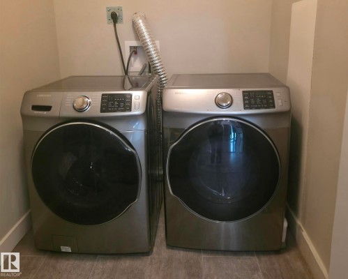Laundry room with baseboards and washer and clothes dryer - 437 1818 Rutherford Road, Edmonton, AB - Indoor Photo Showing Laundry Room