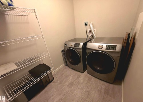 Laundry room featuring washing machine and dryer and light wood finished floors - 437 1818 Rutherford Road, Edmonton, AB - Indoor Photo Showing Laundry Room