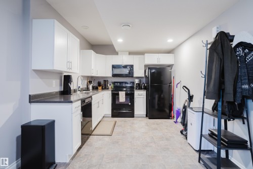 Kitchen featuring black appliances, white cabinets, recessed lighting, and stone finish flooring - 326 West Haven Drive, Leduc, AB - Indoor Photo Showing Kitchen